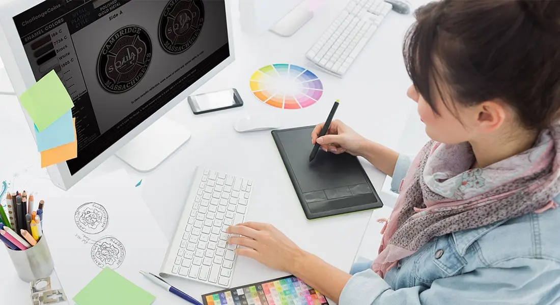 A graphic designer creating a coin design proof on a computer